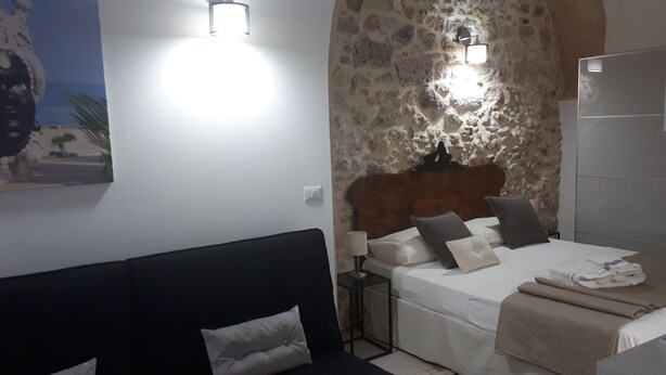 Une chambre à coucher avec un lit, une table de chevet, une lampe et un tableau au mur.