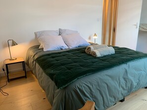 Cozy retreat with a large bed, bedside table, and lamp.