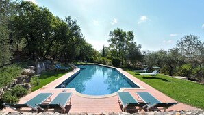 A rectangular swimming pool with a brick deck, surrounded by green grass and trees. - Pesci, Montefiorile, Gaiole in Chianti, Siena and Chianti (Gaiole in Chianti)