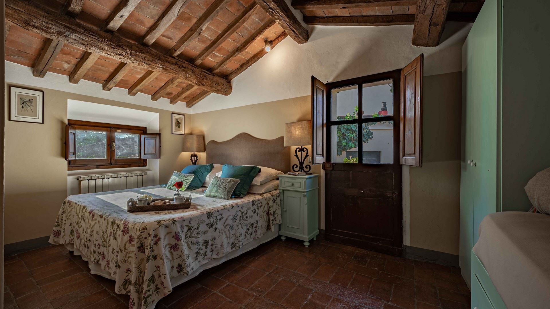 Une chambre à coucher avec un lit, une table de chevet, une fenêtre et une porte.