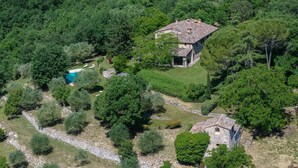 An aerial view of a property with a swimming pool, stone house, and surrounding greenery. - Villa San Michele, Gaiole in Chianti, Siena and Chianti (Gaiole in Chianti)