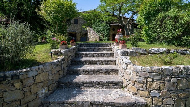 A stone staircase leading to a stone building surrounded by lush greenery and potted plants. - Villa San Michele, Gaiole in Chianti, Siena and Chianti (Gaiole in Chianti)