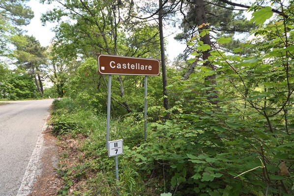 Un panneau de signalisation indiquant la direction de Castellare, avec un indicateur de parcours en dessous.