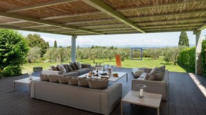 An outdoor seating area with a sofa and tables, overlooking a vineyard. - Castellare de Sernigi, Tavarnelle Val di Pesa, Florence and Chianti (Tavarnelle Val di Pesa)