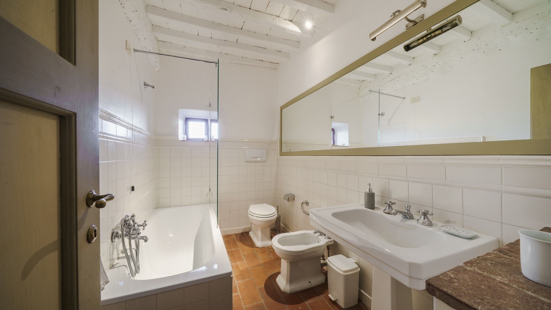 A bathroom with a bathtub, a toilet, and a bidet.