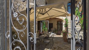 An outdoor patio with a table and chairs, a covered area, and decorative metalwork. - Le Volte, Gaiole in Chianti, Siena and Chianti (Gaiole in Chianti)
