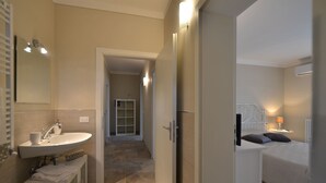 Una habitación de hotel con baño, cama y vestidor.