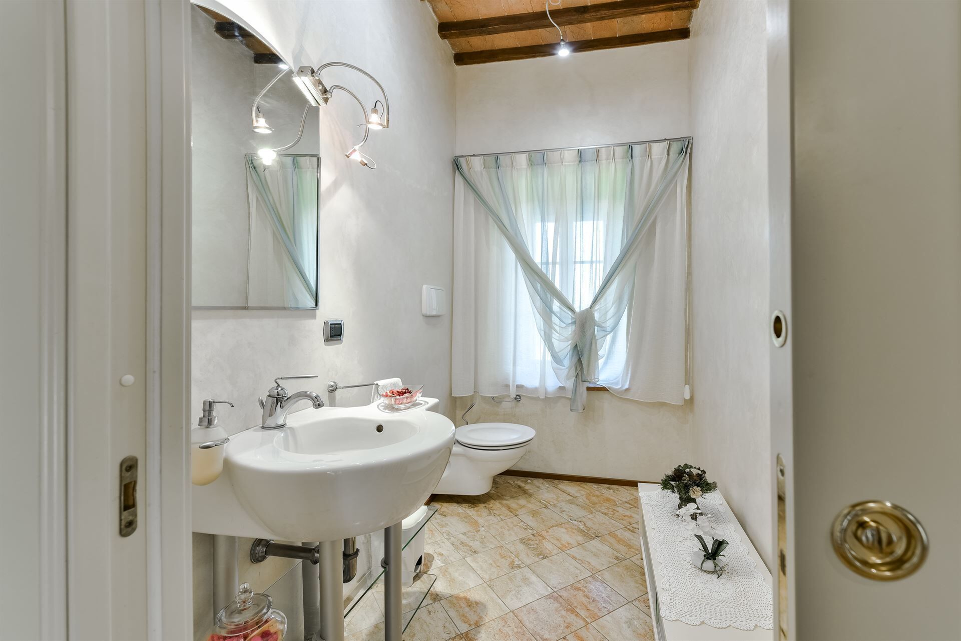 Een badkamer met een wit wastafel, een toilet en een douchehoek.