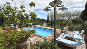 Uma área de piscina com espreguiçadeiras e um pergolado.