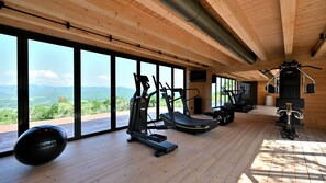 Une salle de sport spacieuse, dotée de grandes fenêtres qui offrent une vue imprenable sur les montagnes.