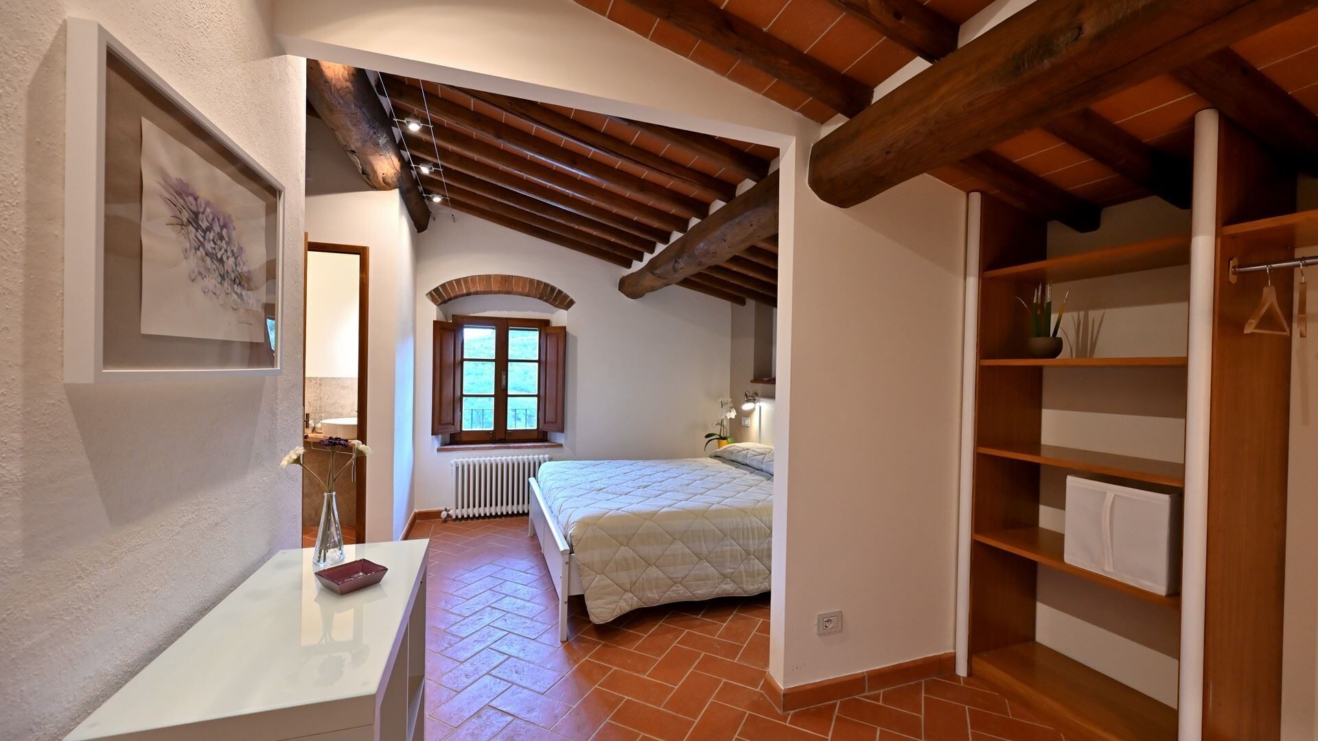 Une chambre avec un plafond en bois, un lit, un radiateur et une fenêtre.