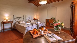 A cozy bedroom with two beds, a wooden table with breakfast, and a vase of flowers. - Casale del Lago, San Casciano in Val di Pesa, Florence and Chianti (San Casciano in Val di Pesa)