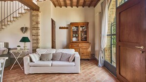 Un salon chaleureux avec un canapé, un meuble en bois et un escalier.