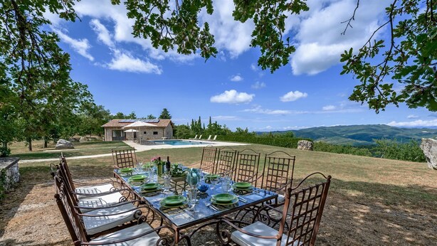 An outdoor dining area with a table set for six, surrounded by chairs with cushioned seats. - Calafralina, Radda in Chianti, Siena and Chianti (Radda in Chianti)