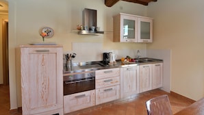 A kitchen with wooden cabinetry, a stainless steel range, and a tiled backsplash.