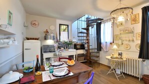 A compact kitchen with a dining area, a built-in oven, and a small dining table set for two. - Il Paretaio, Montevarchi, Arezzo and Cortona (Montevarchi)