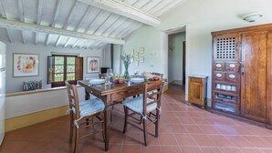A dining area with a wooden table and chairs, a tiled floor, and a rustic ceiling. - Casetta con Vista, Montebuoni, Gaiole in Chianti, Siena and Chianti (Gaiole in Chianti)