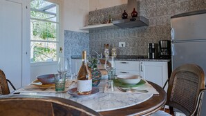 A kitchen with a marble countertop, a dining table with chairs, and a refrigerator. - Scorpione, Montefiorile, Gaiole in Chianti, Siena and Chianti (Gaiole in Chianti)
