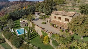 A stone villa with a swimming pool, surrounded by lush gardens and a hilly landscape. - Villa Tegognano, Cortona, Arezzo and Cortona (Cortona)