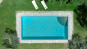 An aerial view of a rectangular swimming pool with a tiled edge, surrounded by grass and trees. - Trifoglio, Gaiole in Chianti, Siena and Chianti (Gaiole in Chianti)
