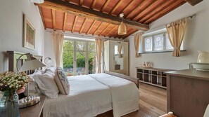 A bedroom with a bed, bedside table, lamp, and a view of the outdoors. - Trifoglio, Gaiole in Chianti, Siena and Chianti (Gaiole in Chianti)