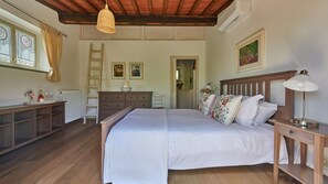 A bedroom with a wooden bed, bedside table, lamp, dresser, and a ladder against the wall. - Trifoglio, Gaiole in Chianti, Siena and Chianti (Gaiole in Chianti)