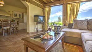 Una sala de estar acogedora con una mesa de centro de madera, un sofá y un televisor.