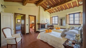 A spacious bedroom with a large bed, a fireplace, and a view of the outside. - Casale di Campioni, Buggiano, Pistoia and Montecatini Terme (Buggiano)