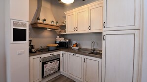 A kitchen with white cabinets, a wooden countertop, a stove, and a sink. - Casa di Campagna Pianelli, Pergine Valdarno, Arezzo and Cortona (Pergine Valdarno)