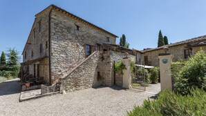 A stone building with a gravel driveway and a covered outdoor seating area. - Bella Vista, Montebuoni, Gaiole in Chianti, Siena and Chianti (Gaiole in Chianti)