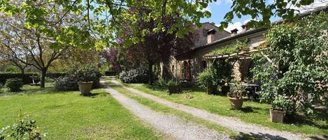 A garden path leading to a rustic building with stone walls and a covered patio area.