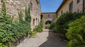 A courtyard with stone buildings, a gravel path, and greenery. - Santa Lucia, Montebuoni, Gaiole in Chianti, Siena and Chianti (Gaiole in Chianti)