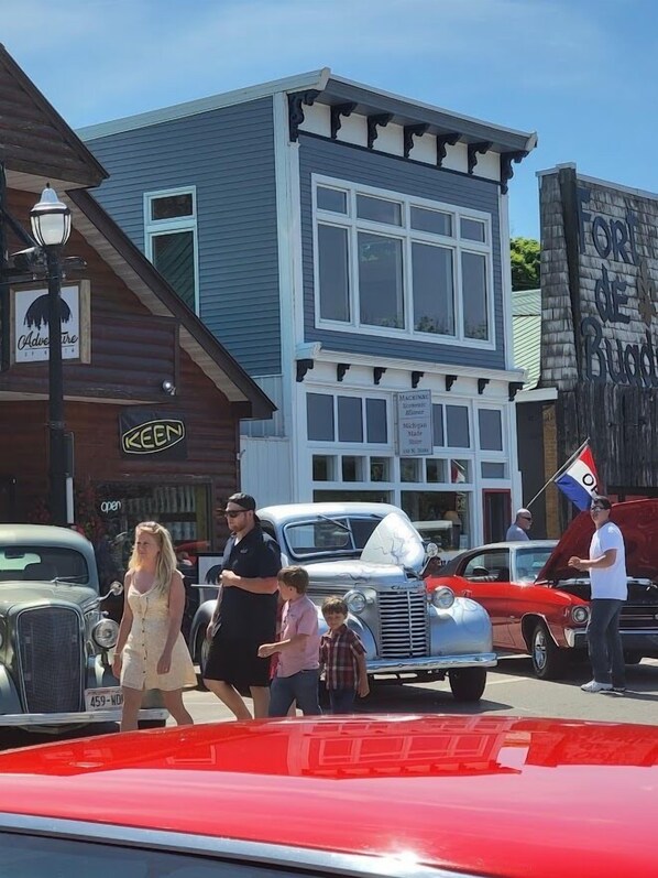 A vintage car parade with people and classic cars in a town setting. - St Ignace Loft - Downtown St Ignace (Saint Ignace)