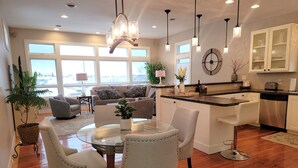 A modern kitchen with white cabinets, a stainless steel dishwasher, and a countertop with a toaster. - St Ignace Loft - Downtown St Ignace (Saint Ignace)