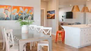 A modern kitchen with white cabinetry, a central island, and a dining area with white chairs. - 🏜️Zion Desert🏜️ - Desert Retreat | Pool + Amenities | Perfect family getaway (Washington)