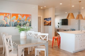 Enjoy meals in the kitchen and dining area, featuring a sink, flat-screen TV, and a dining table with chairs.