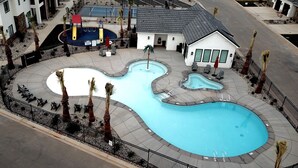 A swimming pool with a unique design, surrounded by lounge chairs and palm trees. - 🏜️Zion Desert🏜️ - Desert Retreat | Pool + Amenities | Perfect family getaway (Washington)