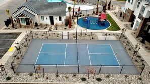 Enjoy a game of tennis surrounded by lush gardens and a refreshing pool with a fun slide.
