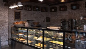Vitrina de pastelería con diferentes productos horneados y un menú en una pizarra.