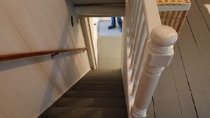 Un escalier avec une rampe en bois et des balustres blanches.