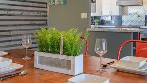 A modern kitchen with a central island, a dining area with a wooden table, and a hanging light fixture. - Most desirable neighborhood in Scottsdale.  2 masters, private 1 acre lot (Scottsdale)