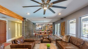 A spacious living room with leather sofas, a wooden coffee table, and a ceiling fan. - Most desirable neighborhood in Scottsdale.  2 masters, private 1 acre lot (Scottsdale)