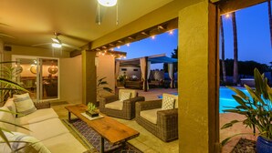 An outdoor patio area with wicker furniture, a pool, and a covered seating area. - Most desirable neighborhood in Scottsdale.  2 masters, private 1 acre lot (Scottsdale)