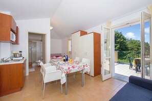 A compact kitchen with a dining area, a balcony with a view, and a sliding glass door leading to a patio. - Porto Letizia Tulipano 7, Porlezza, Italy (Porlezza)