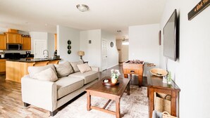 A modern living room with a sofa, coffee table, and a TV mounted on the wall.