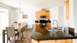 A modern kitchen with wooden cabinets, a stainless steel sink, and a granite countertop.