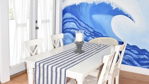 A dining area with a white table, chairs, and a ceiling fan. - 
Cozy Waterfront Beach House with Private Beach/Pier/Tennis Courts (Pensacola)
