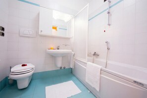 A bathroom with a toilet, sink, and bathtub.