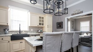 A kitchen with a central island, bar stools, and pendant lighting. - Beautiful City View GEM of NOLA, Vacation Luxury! (New Orleans)