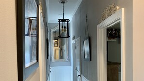 A hallway with a wooden floor, white wainscoting, and a ceiling light fixture. - Beautiful City View GEM of NOLA, Vacation Luxury! (New Orleans)